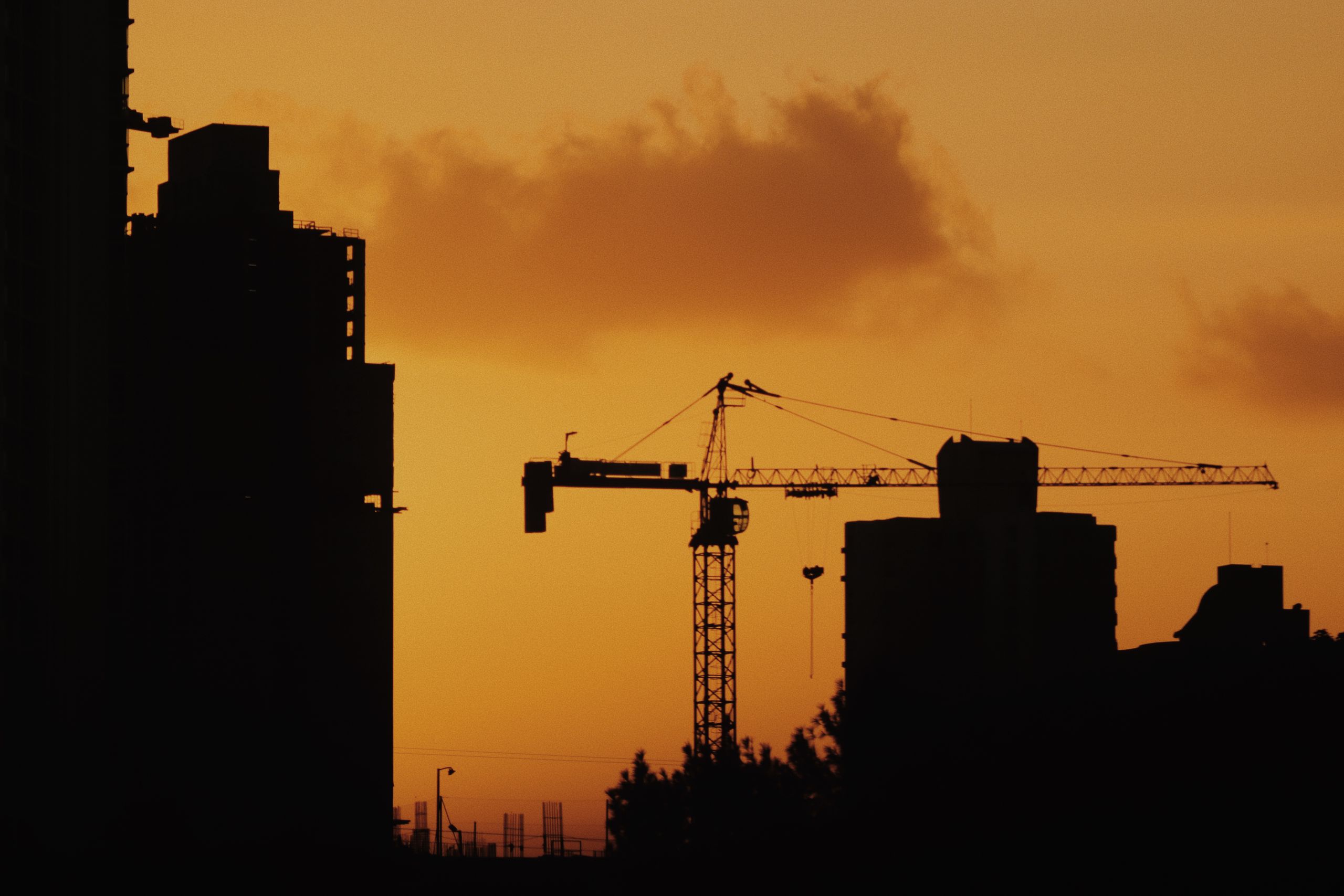Construction Crane Against Blazing Sunset Heat Sky